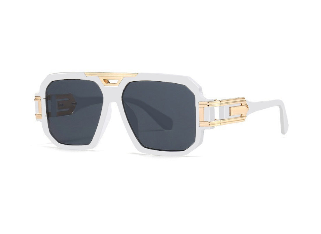 A pair of sunglasses with white frames and gold accents.