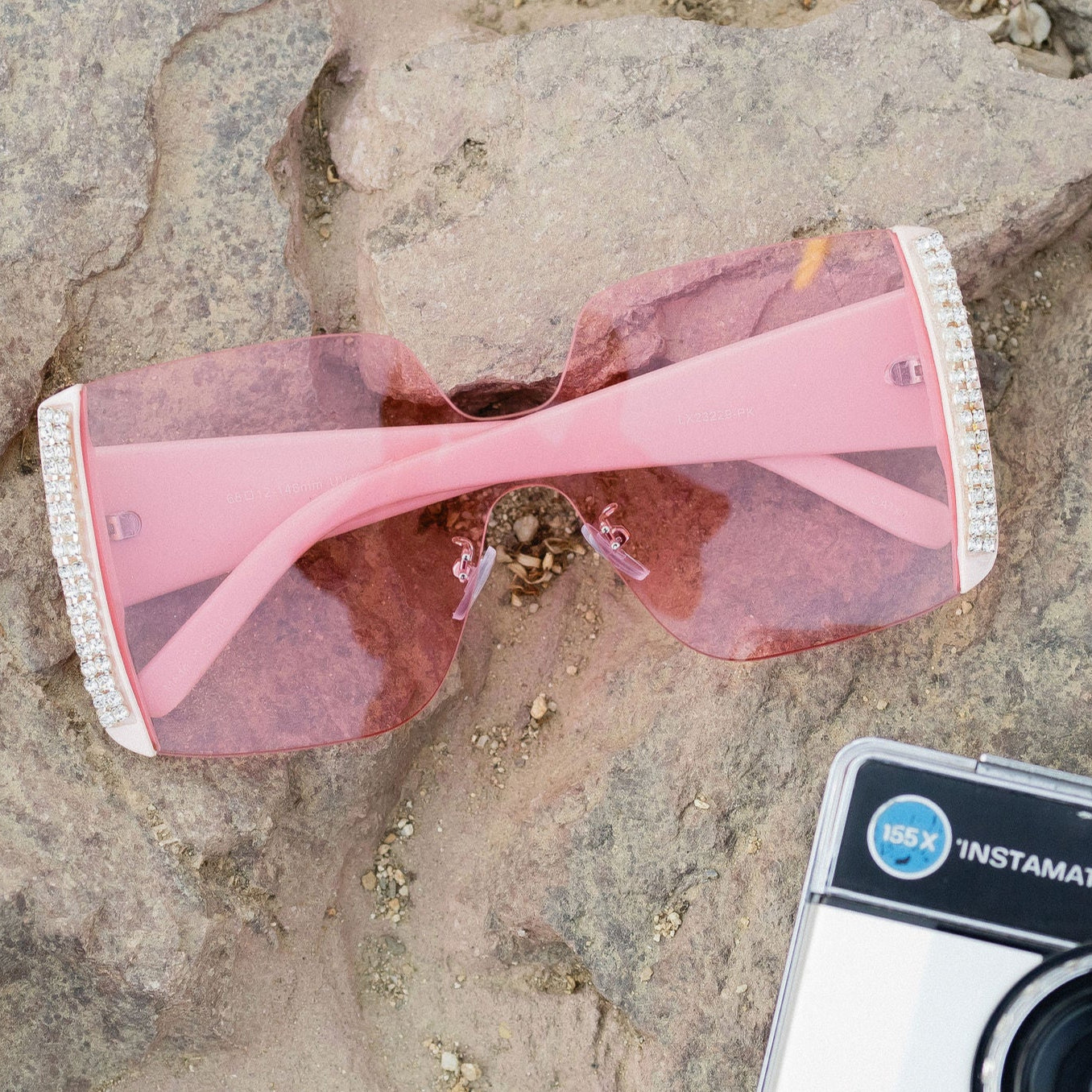 Oversized rimless sunglasses with pink lenses and crystal rhinestones on the frames.